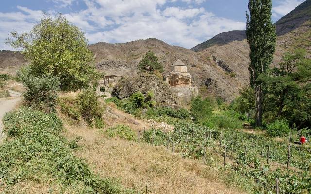 The domed stone church of Ateni Sioni among trees in the green Tana valley