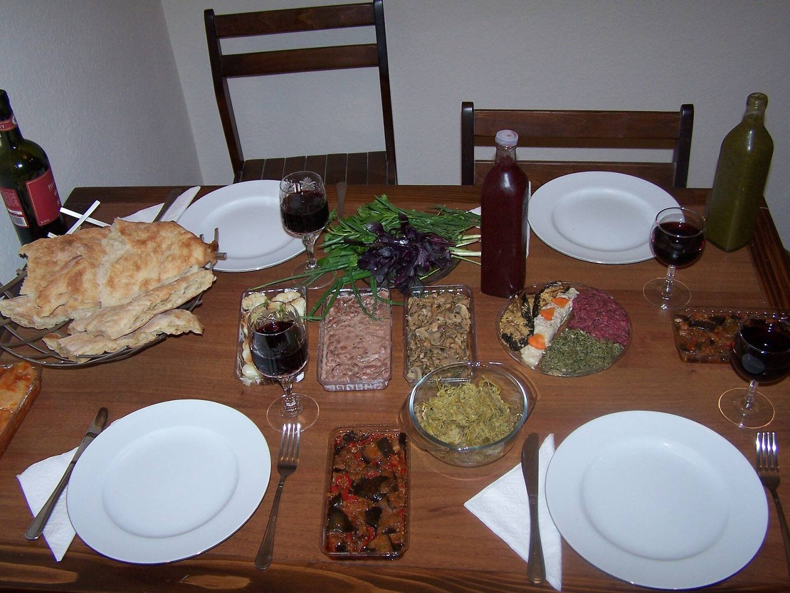 A Georgian table set with bread, salads, sauces, wine and glasses