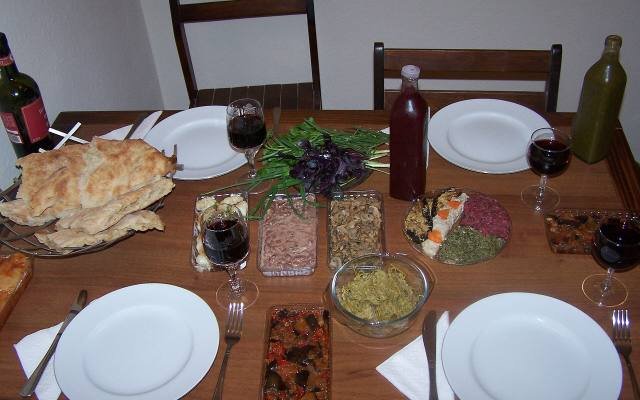 A Georgian table set with bread, salads, sauces, wine and glasses