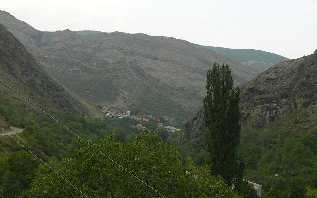 The green gorge of the Ateni valley with trees and a village below steep slopes